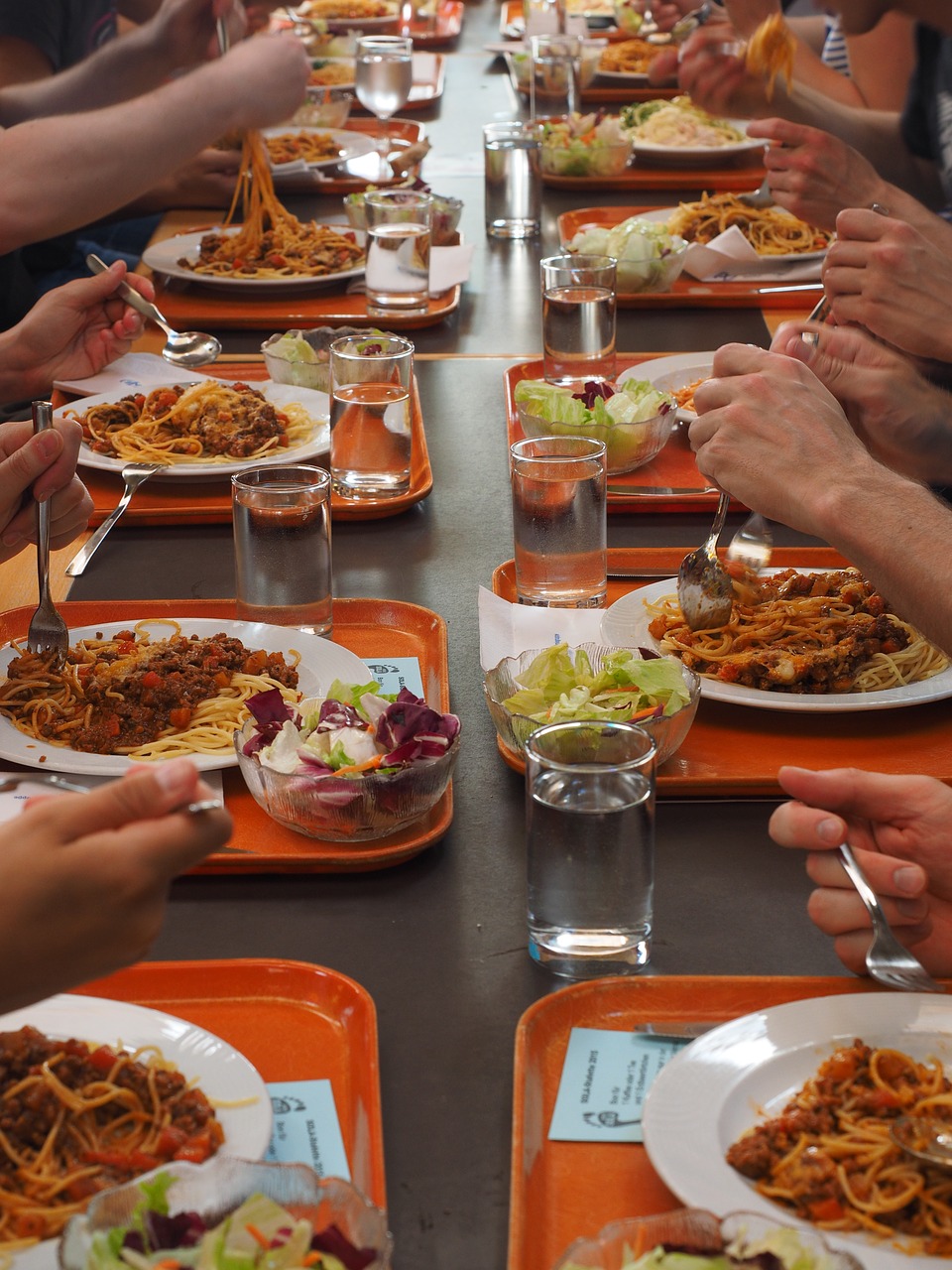 jeunes mangeant des spaghetti à la cantine